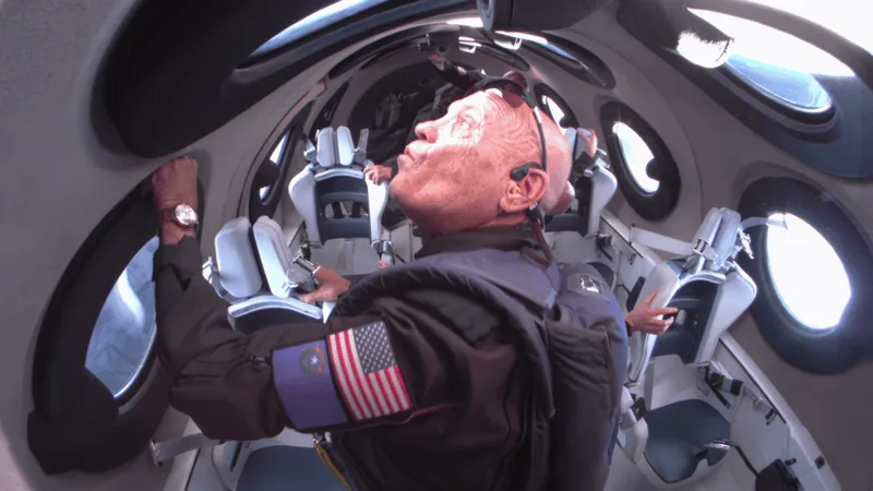 An astronaut floats between the windows of a Virgin Galactic cabin