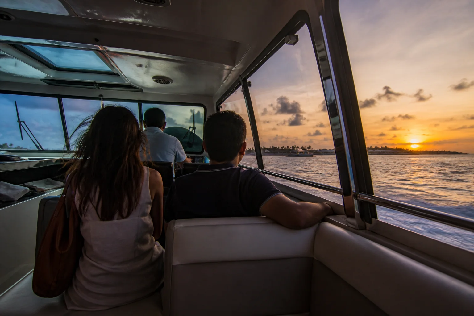 Reales geschlossenes Speedboat mit Reisenden bei Abendlicht auf den Malediven