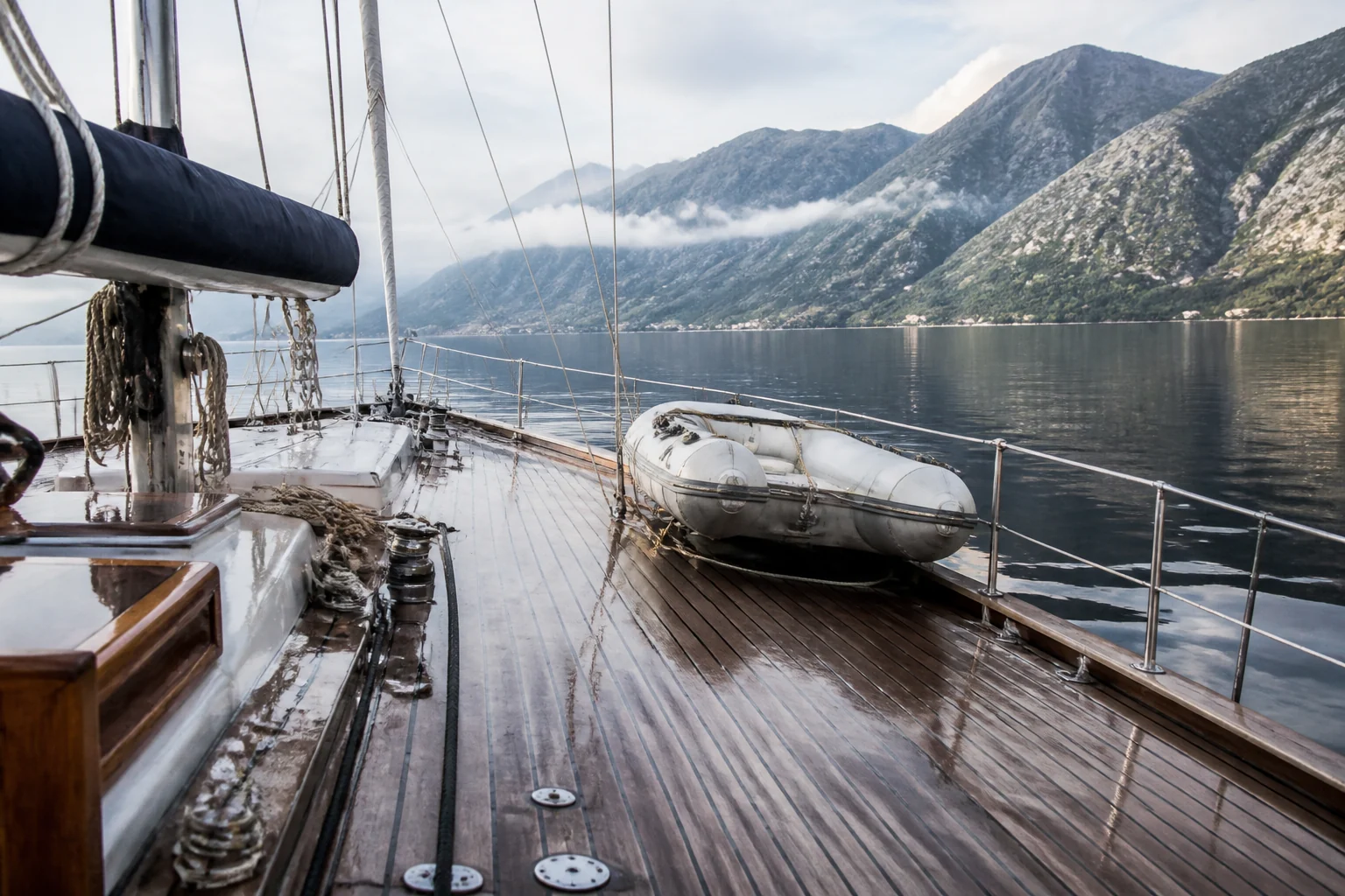 Wet deck of a real sailing yacht with tender and running rigging
