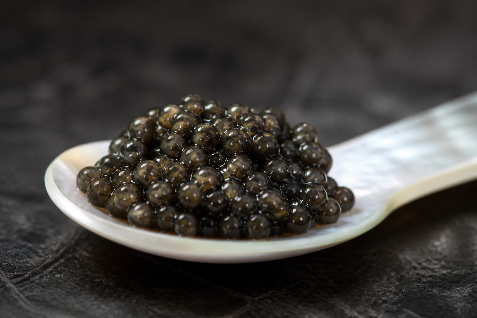 Close view of individual dark caviar eggs on a spoon