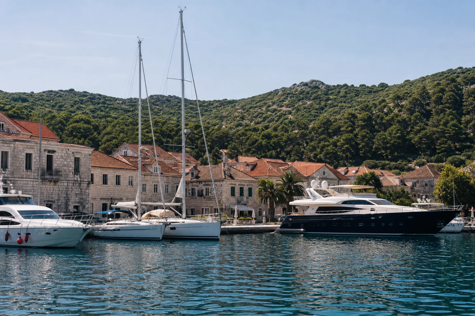 Sailing and motor yachts before the historic waterfront in Vis harbour