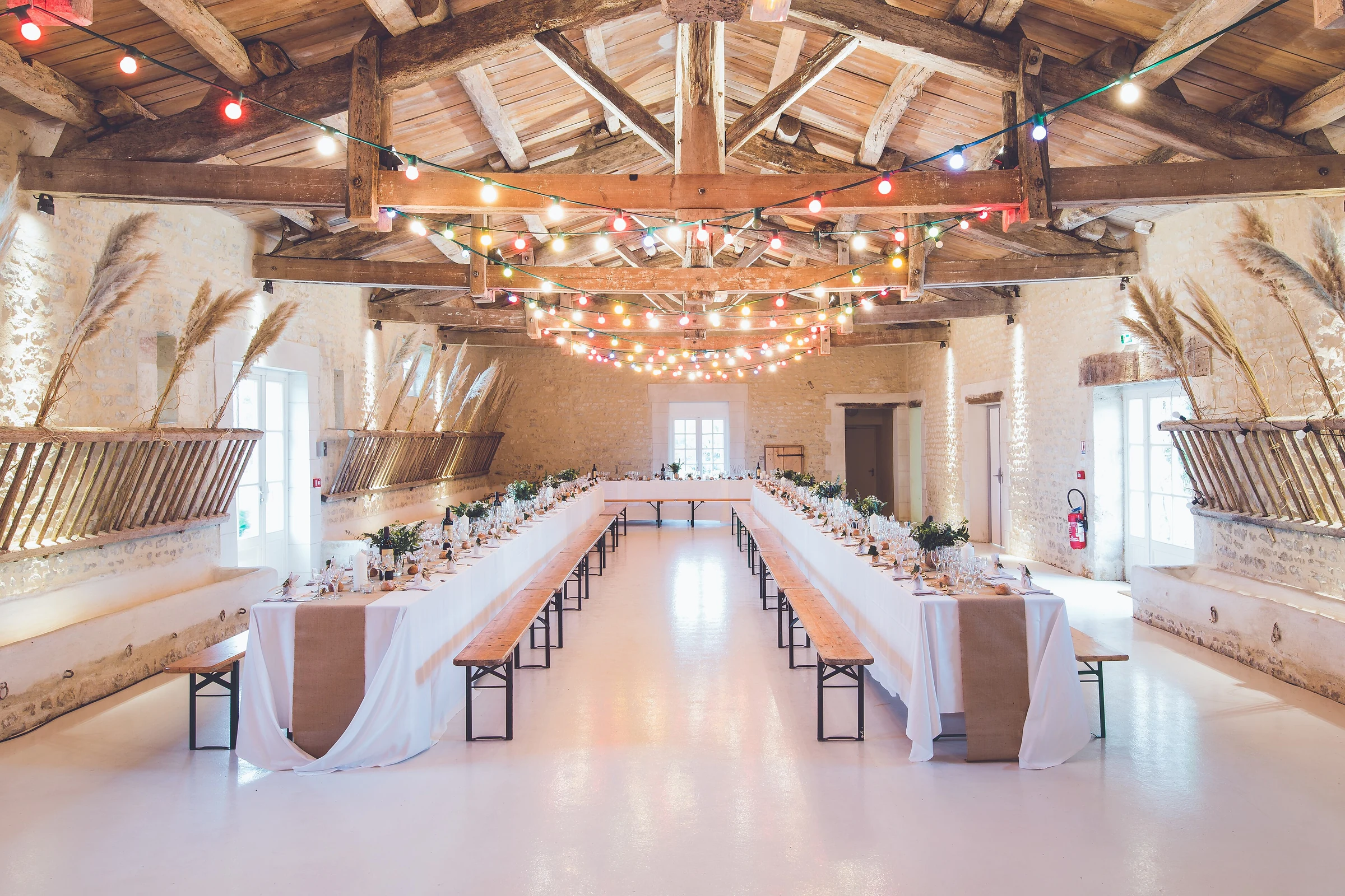Tables de mariage dressées avec bancs en bois à l’Abbaye de la Grâce-Dieu en France