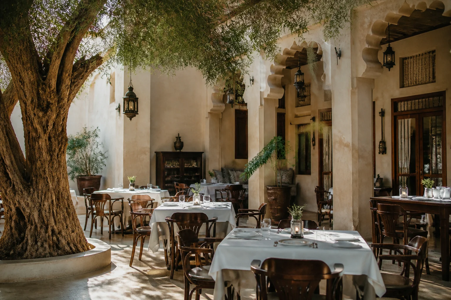 Quiet dining room at Al Fanar Restaurant with a tree and heritage-inspired interior