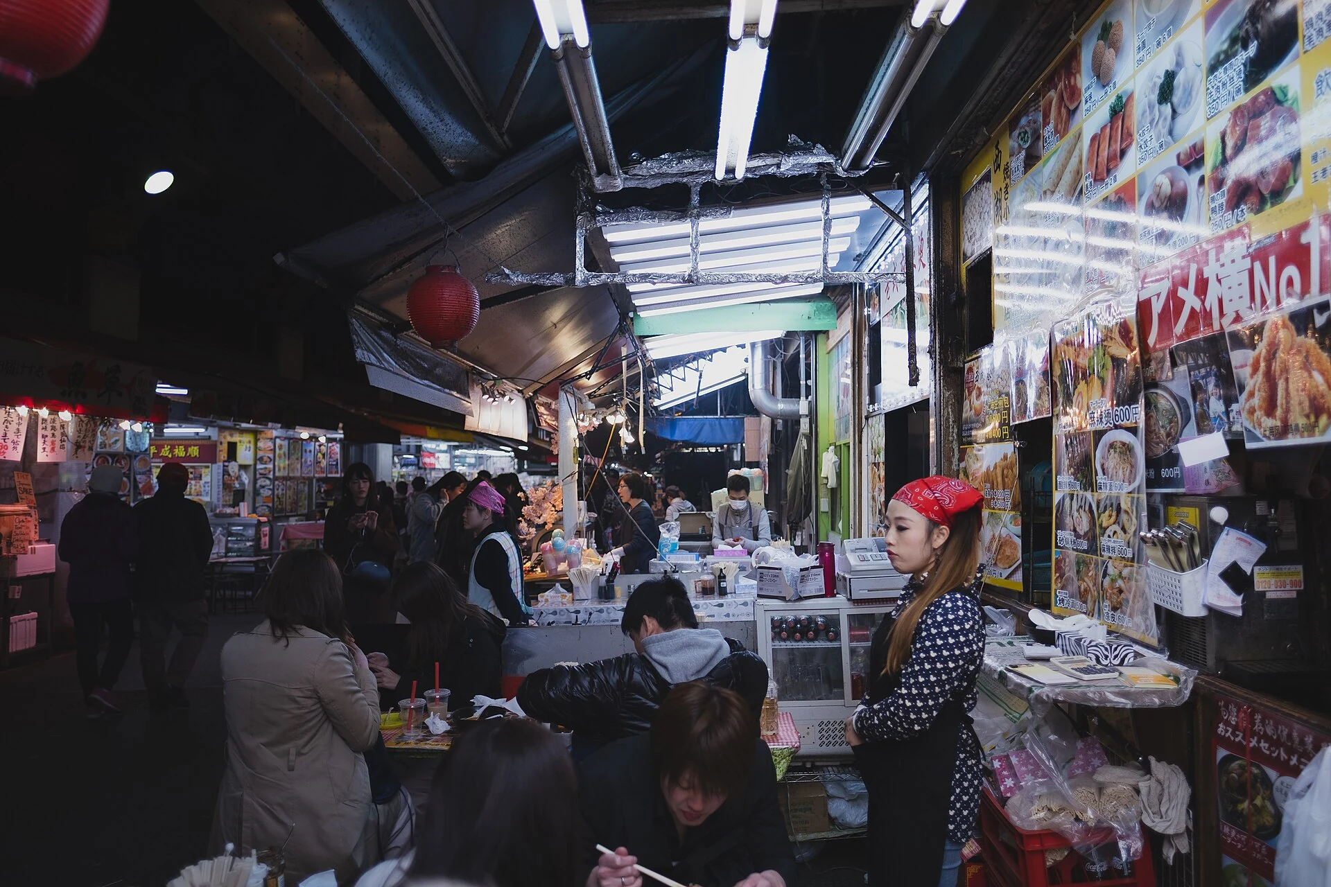 Stands de restauration et clients dans une allée de marché du quartier d’Ueno à Tokyo