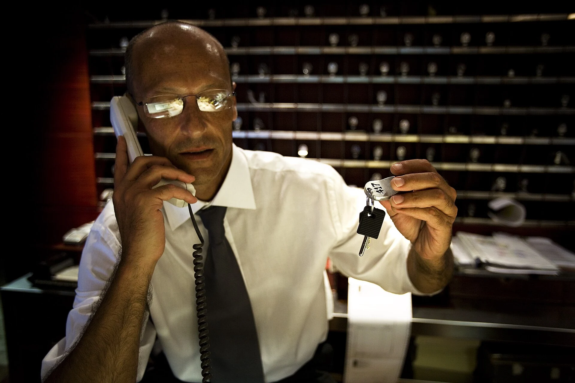 Hotel concierge in Rome holding a telephone and room key