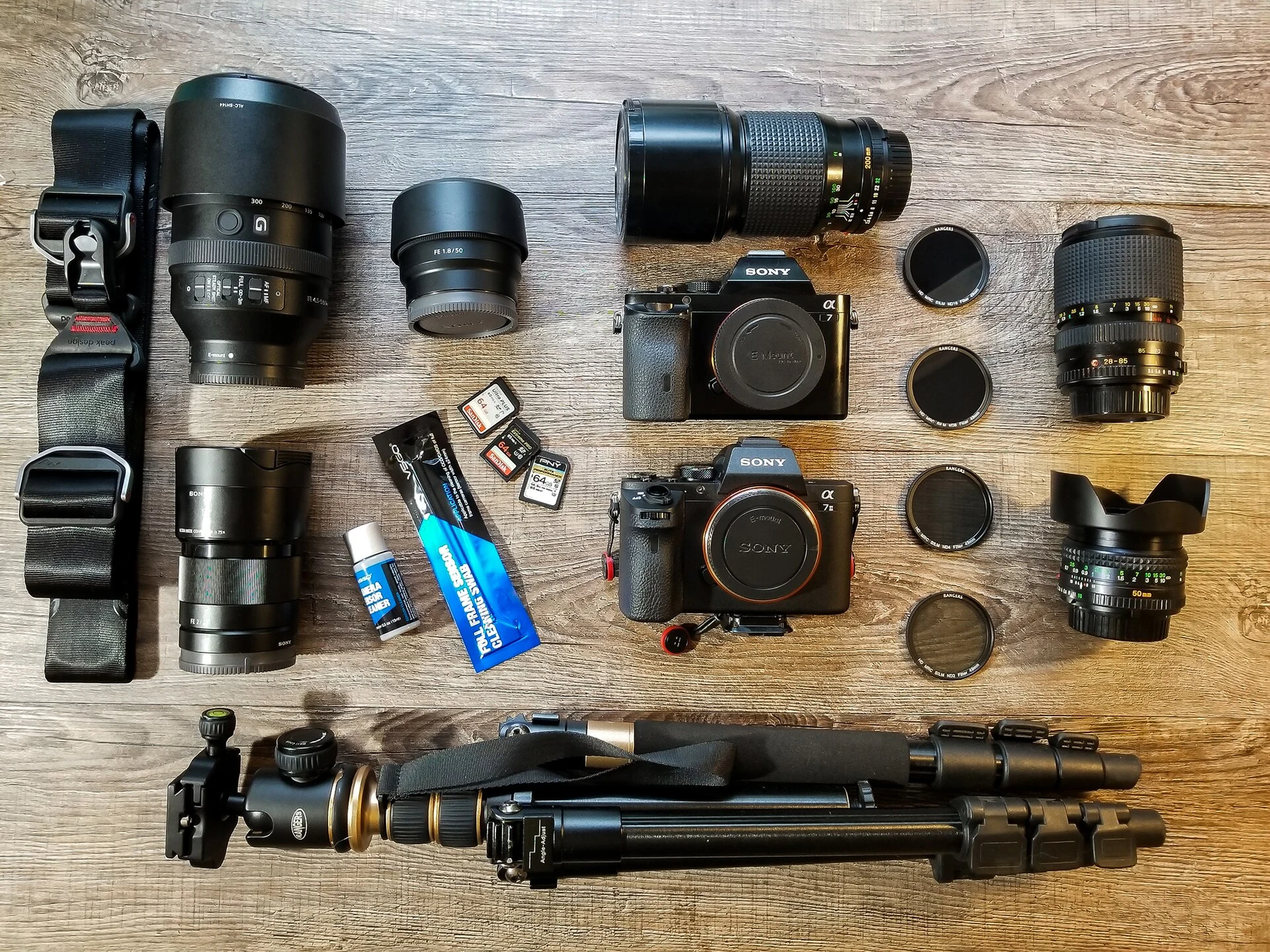 Camera kit laid out with two bodies, lenses and tripods