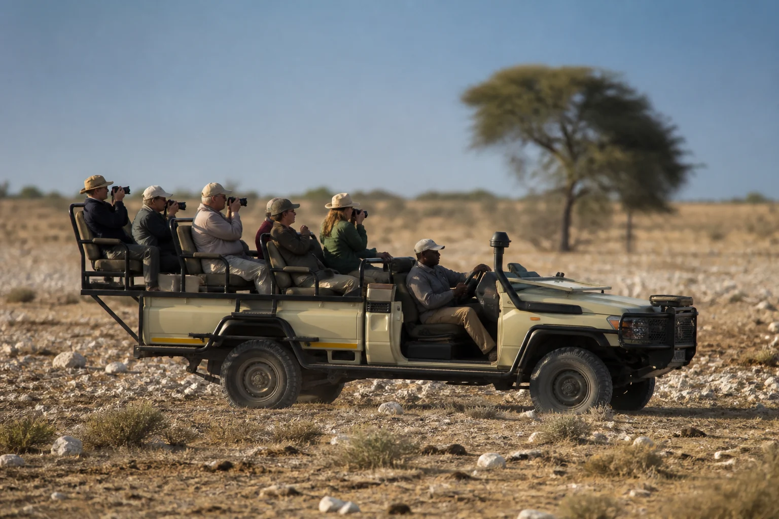 Open game-drive vehicle with raised seating and photographing guests in Namibia