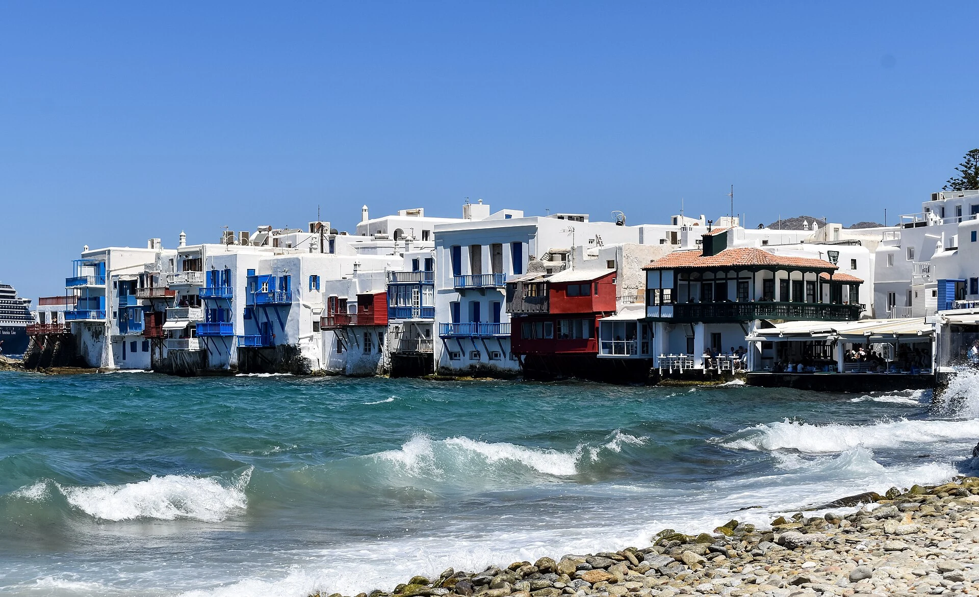 Little Venice waterfront buildings beside wind-driven sea in Mykonos