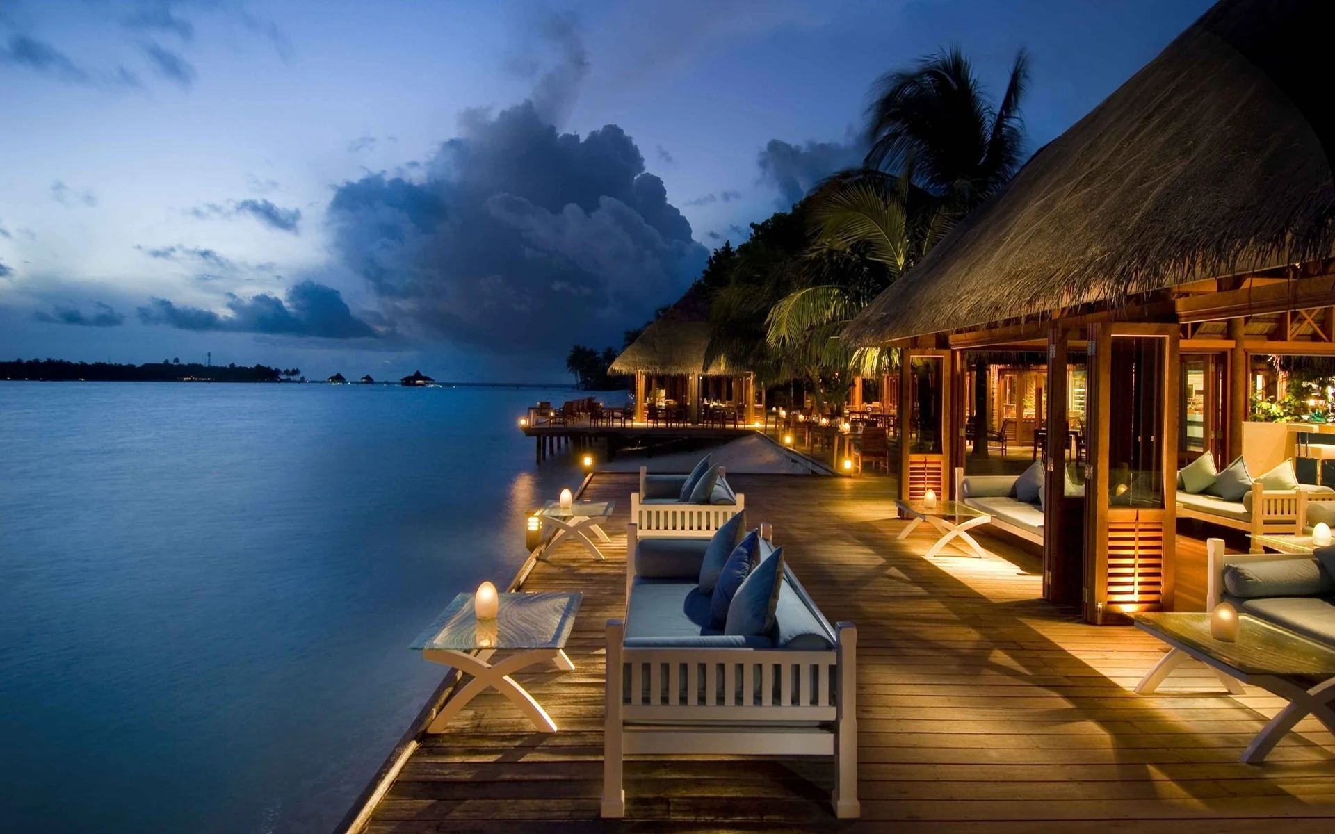 Beleuchtete Terrasse am Wasser im Conrad Maldives Rangali Island am Abend