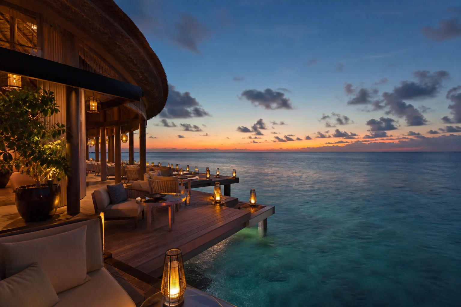 Illuminated waterfront terrace at Conrad Maldives Rangali Island in the evening