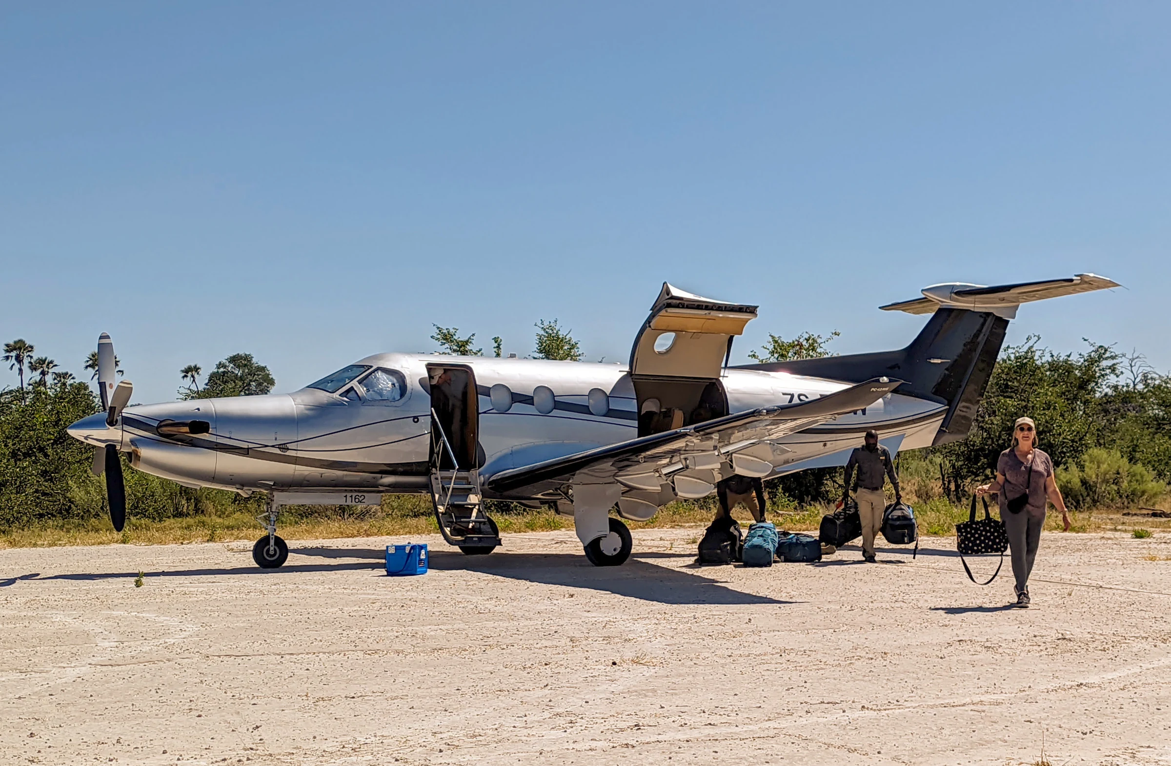 Pilatus PC-12 unloading guests and soft bags on an Okavango airstrip