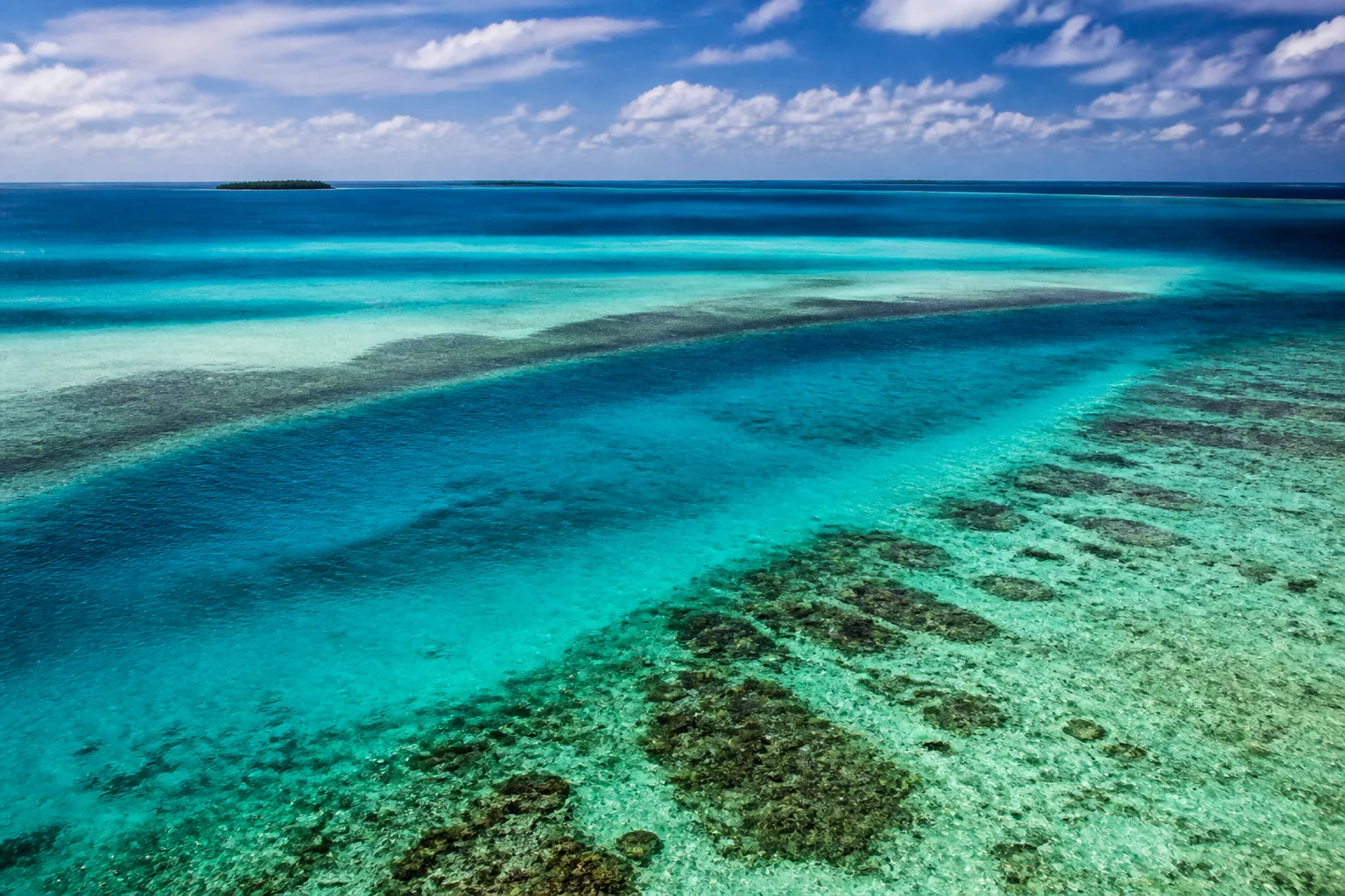 Bands of colour across a lagoon reef in the Maldives’ Meemu Atoll