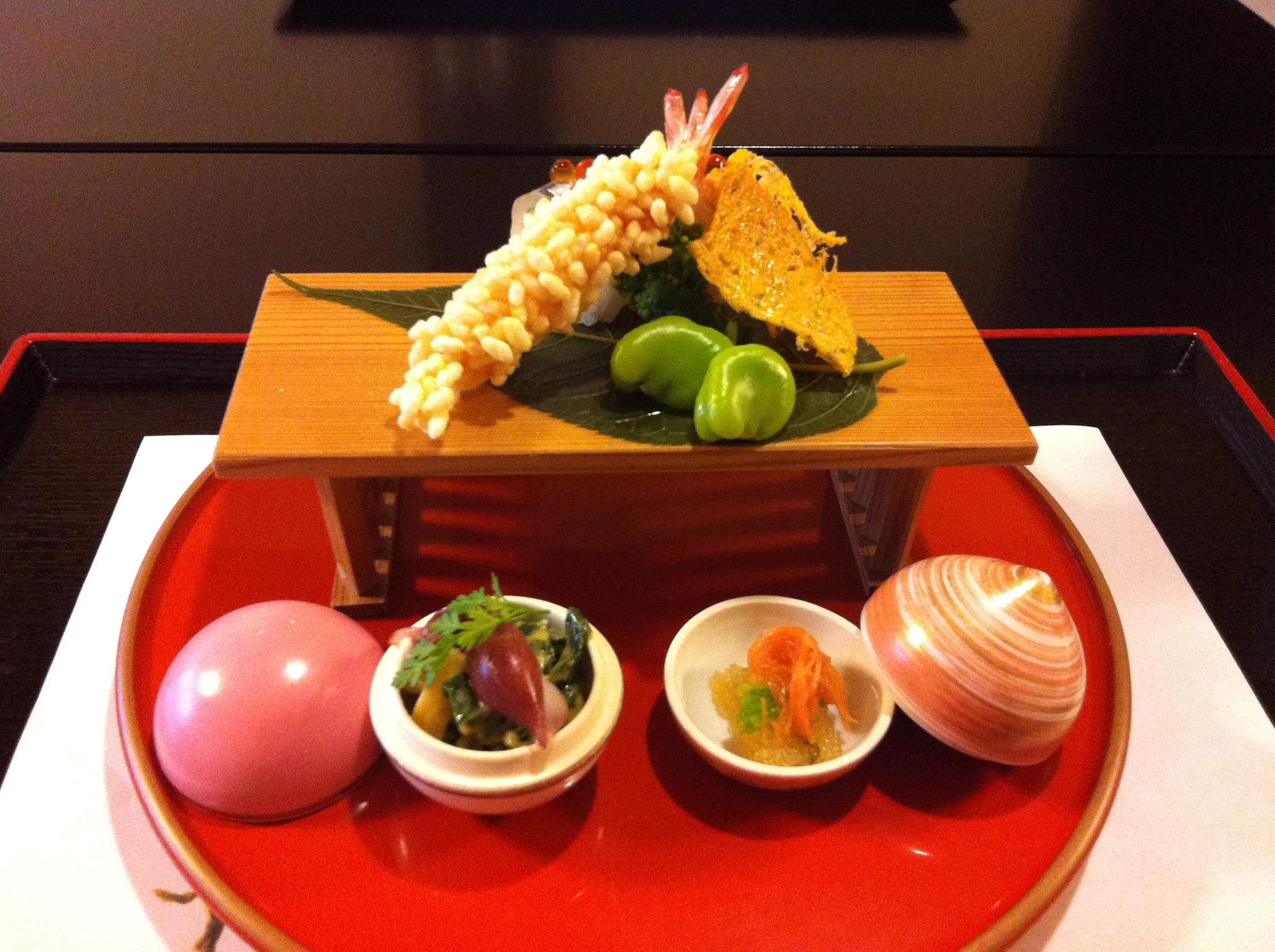 Présentation kaiseki en plusieurs éléments avec crevettes, légumes et petits bols à Kyoto
