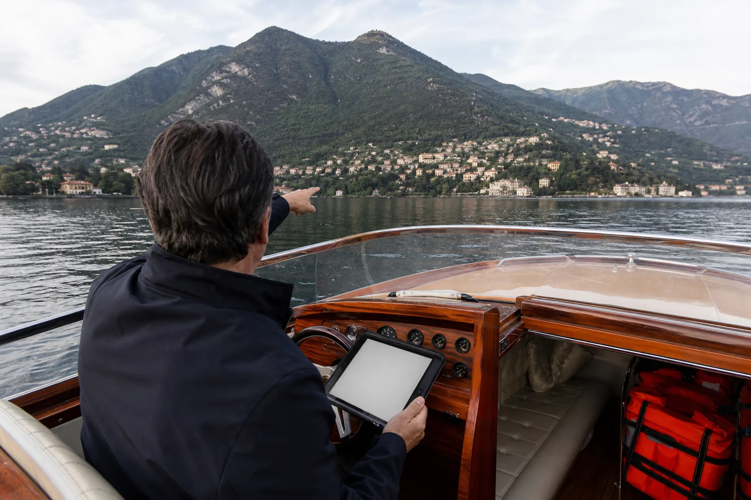 Captain reviewing route and weather aboard a wooden launch on Lake Como