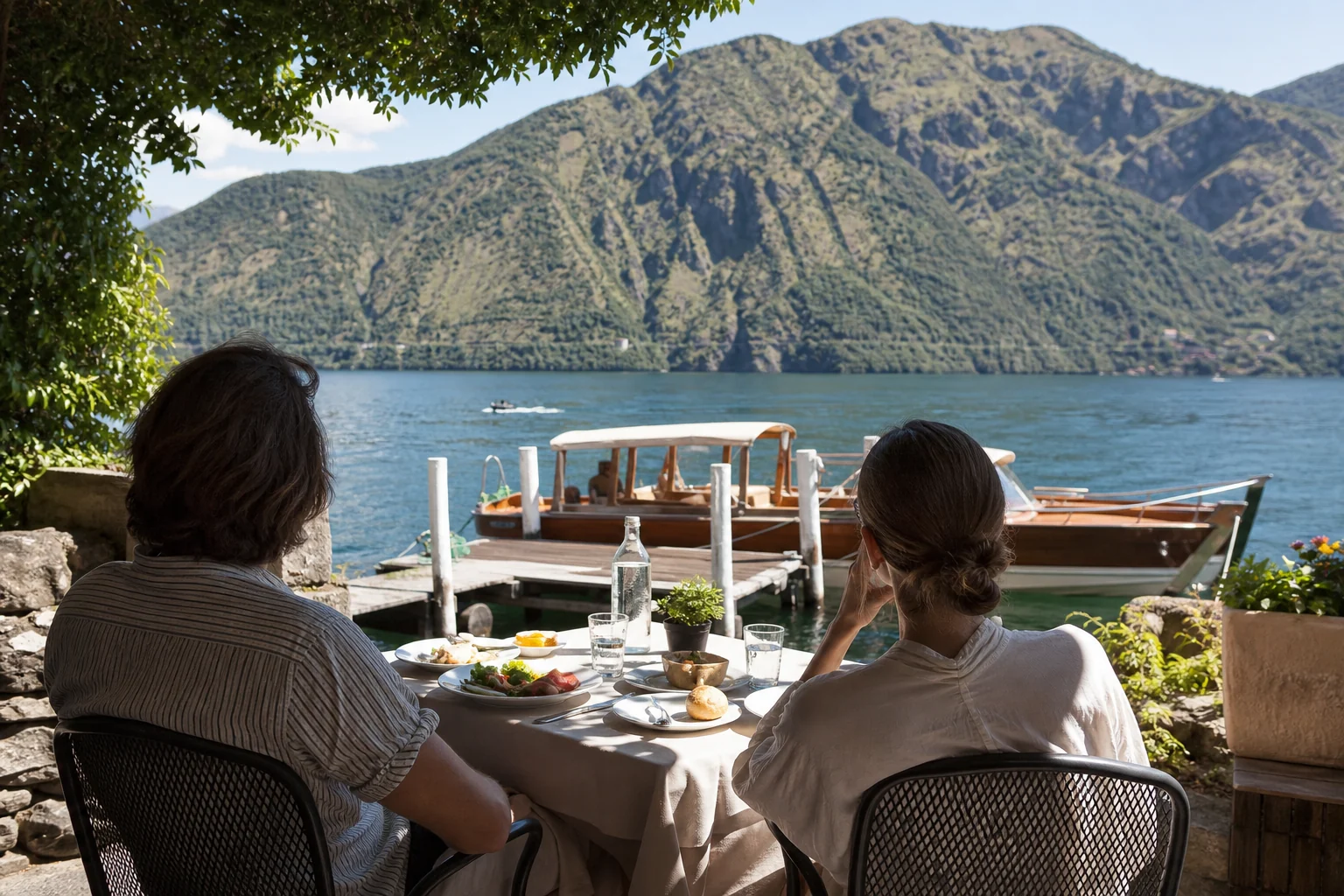 Shaded Lake Como lunch beside a wooden launch with protected seating