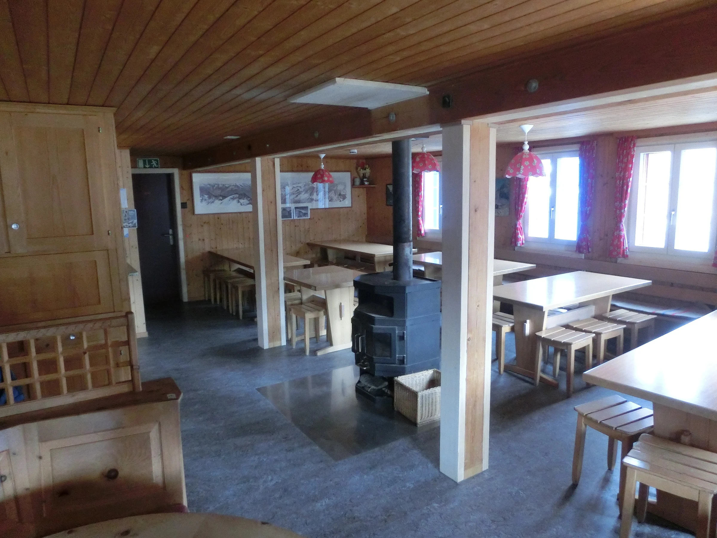 Salle à manger collective lambrissée de bois à la Muttseehütte en Suisse