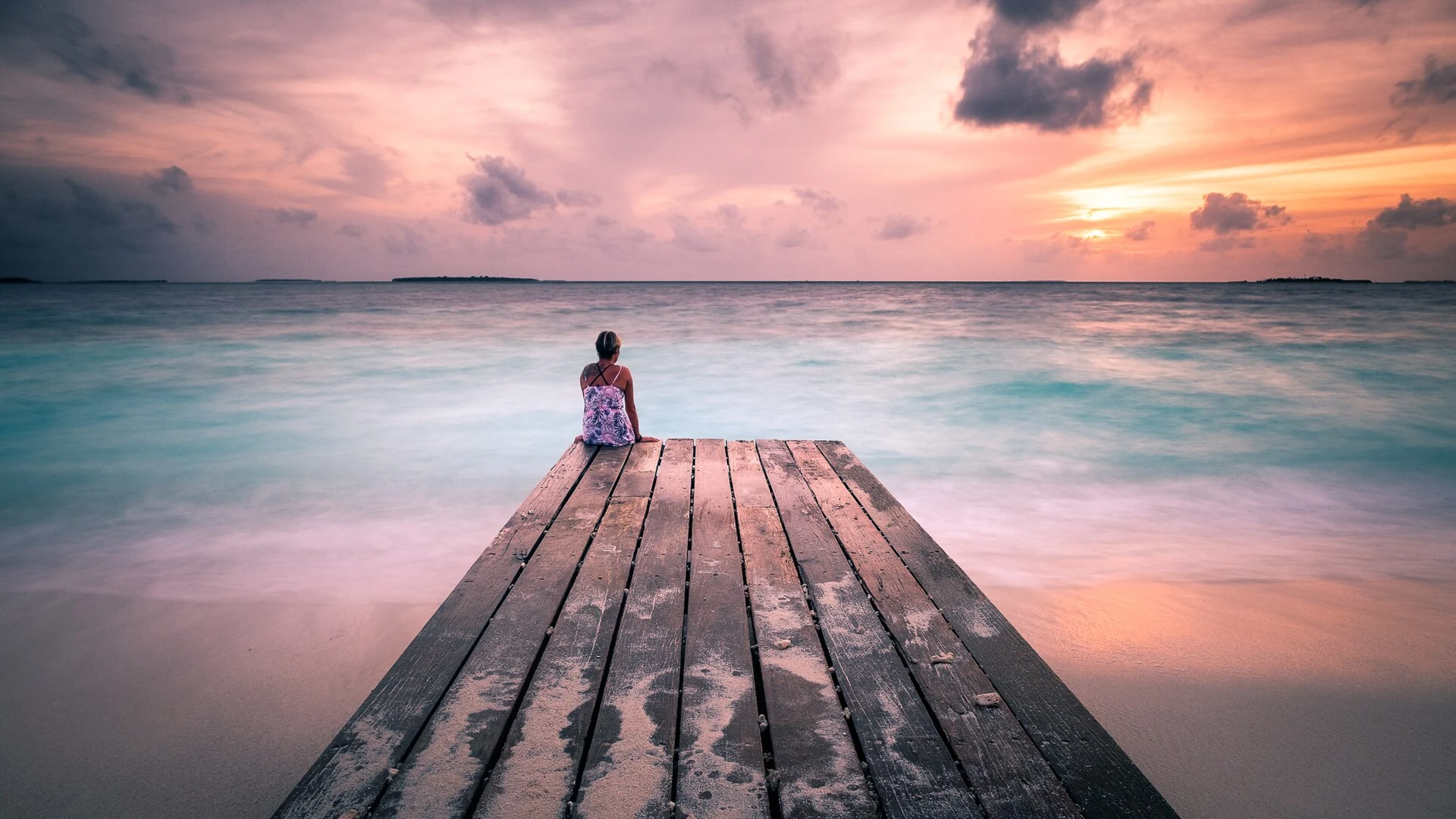 Realer Sonnenuntergang über dem Meer vor einem Holzsteg auf den Malediven