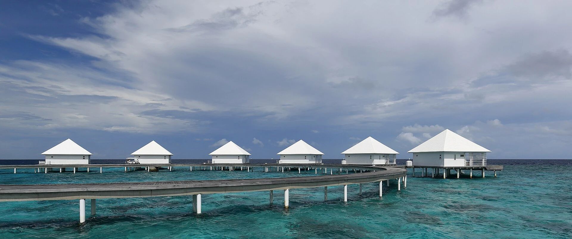 Gebogener Wassersteg mit realen Villen im Diamonds Thudufushi Resort