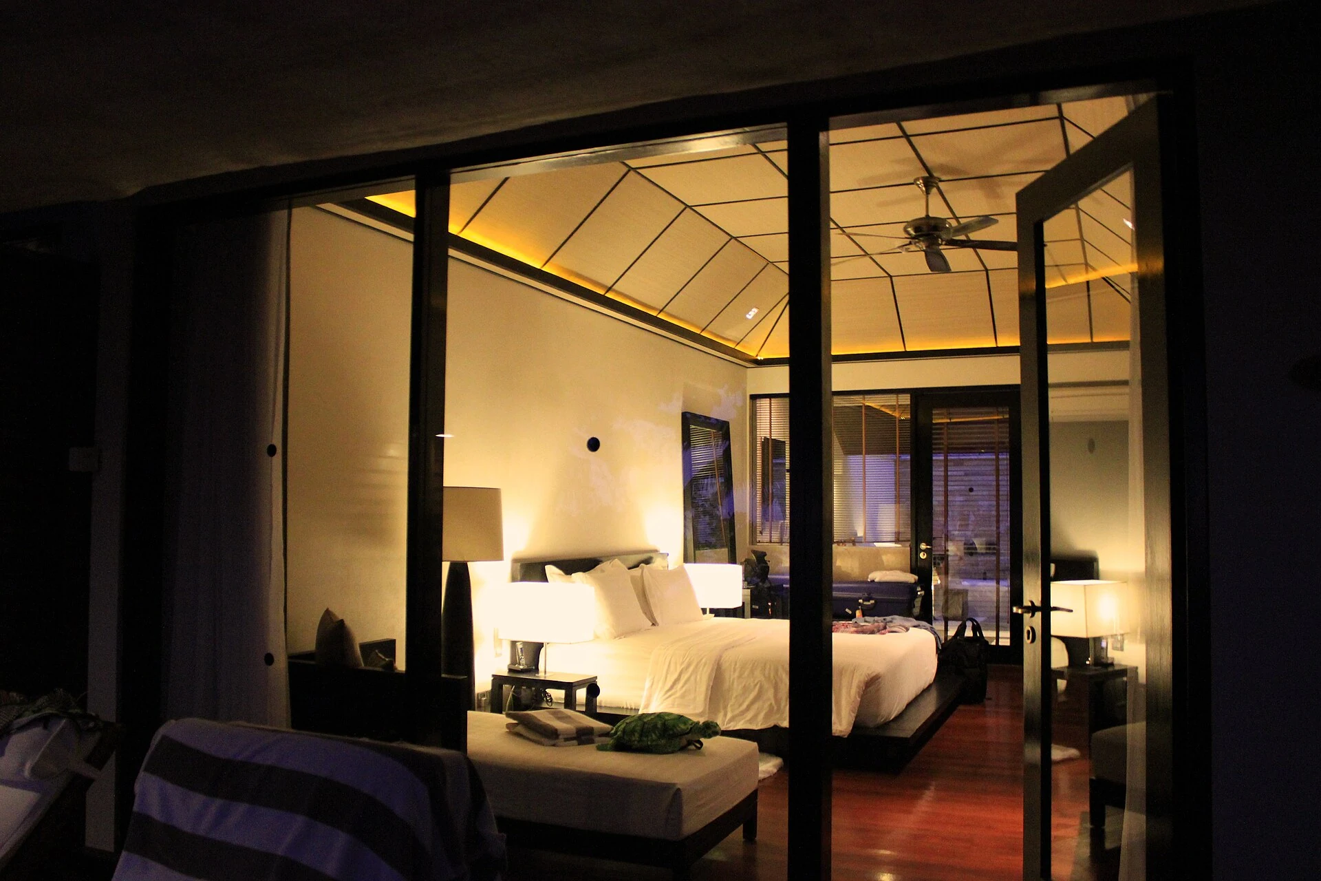 Schlafzimmer einer realen Beach Villa im Lily Beach Resort von der Terrasse durch Glas gesehen