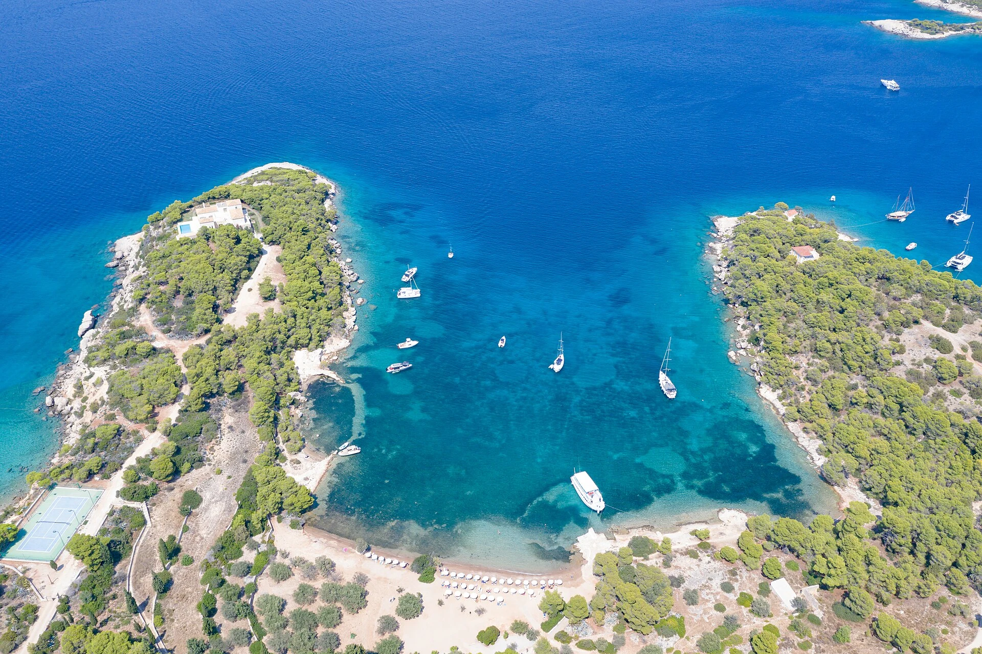 Reale mediterrane Ankerbucht auf Spetses mit mehreren Yachten und sichtbaren Abständen