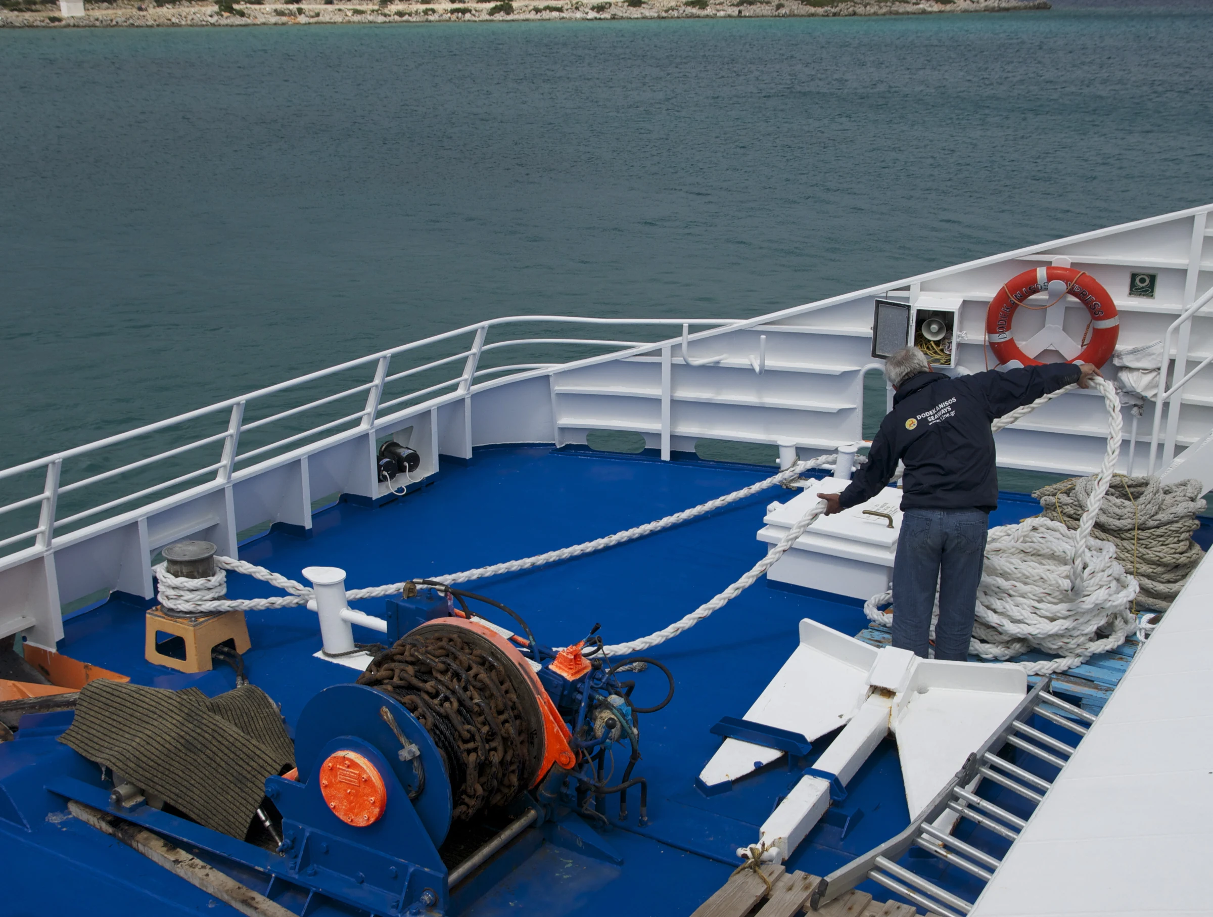Marin travaillant avec amarres et machine de pont près de Symi