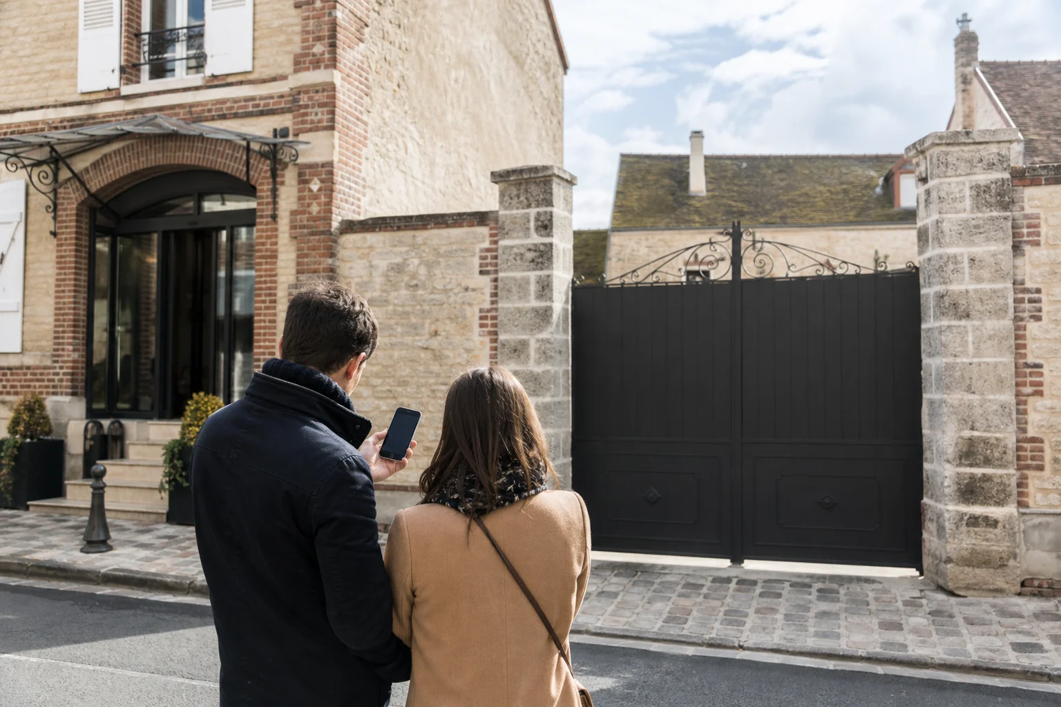 Travellers outside separate entrances of a Champagne house in a wine village