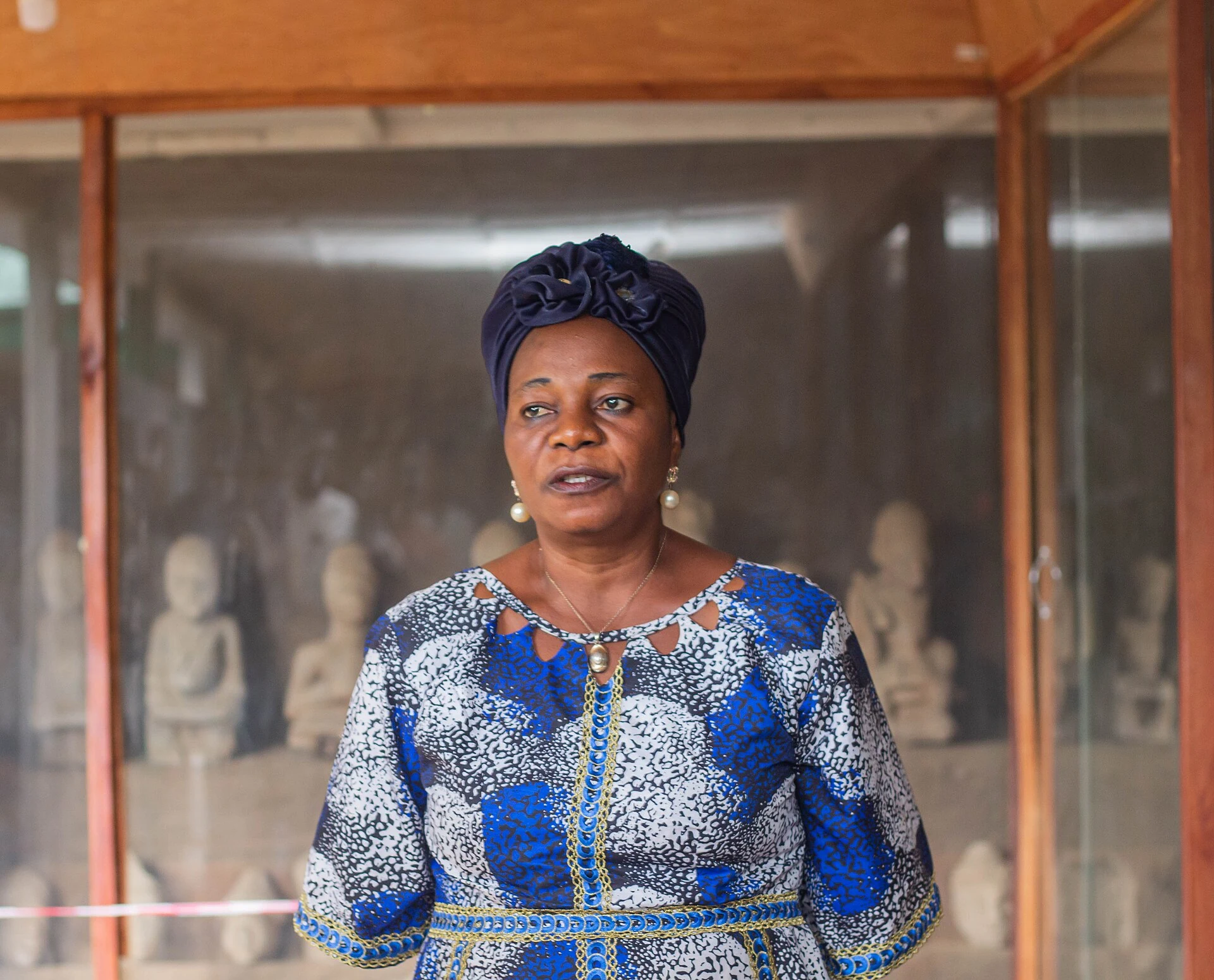 Véritable médiatrice locale devant des objets au musée d'Esie au Nigeria